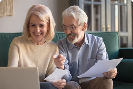 A couple going through their paperwork together at a laptop